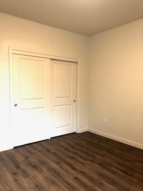 an empty room with white walls and a wooden floor