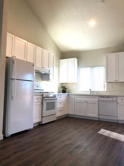 a white kitchen with white cabinets and a refrigerator