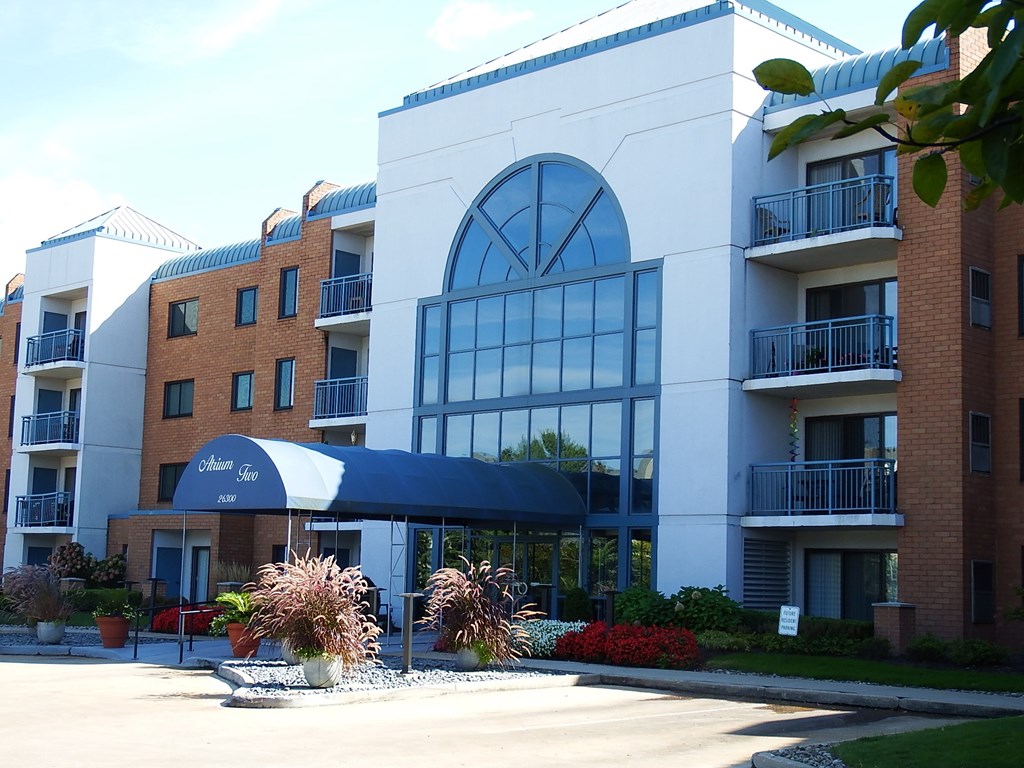 the exterior of a building with a blue awning and a sidewalk