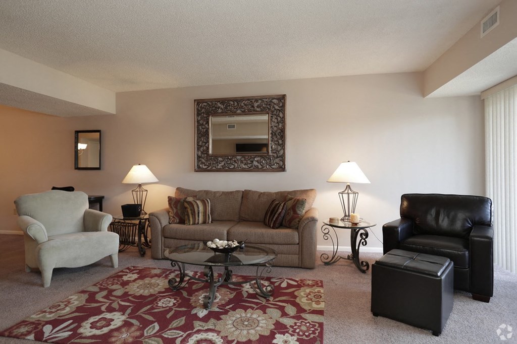 a living room with couches and chairs and a rug