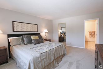 a bedroom with a bed and a door to a living room