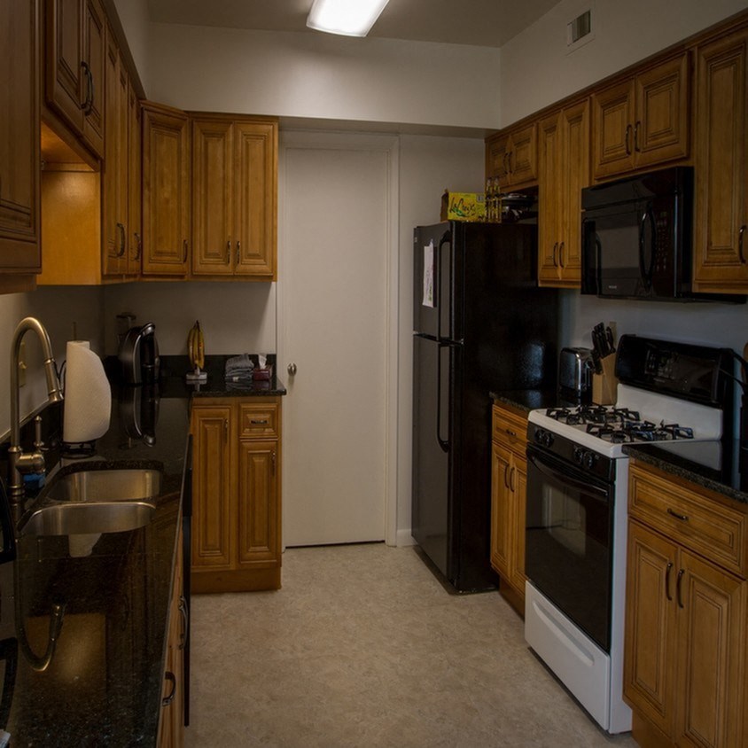 a kitchen with black appliances and wooden cabinets