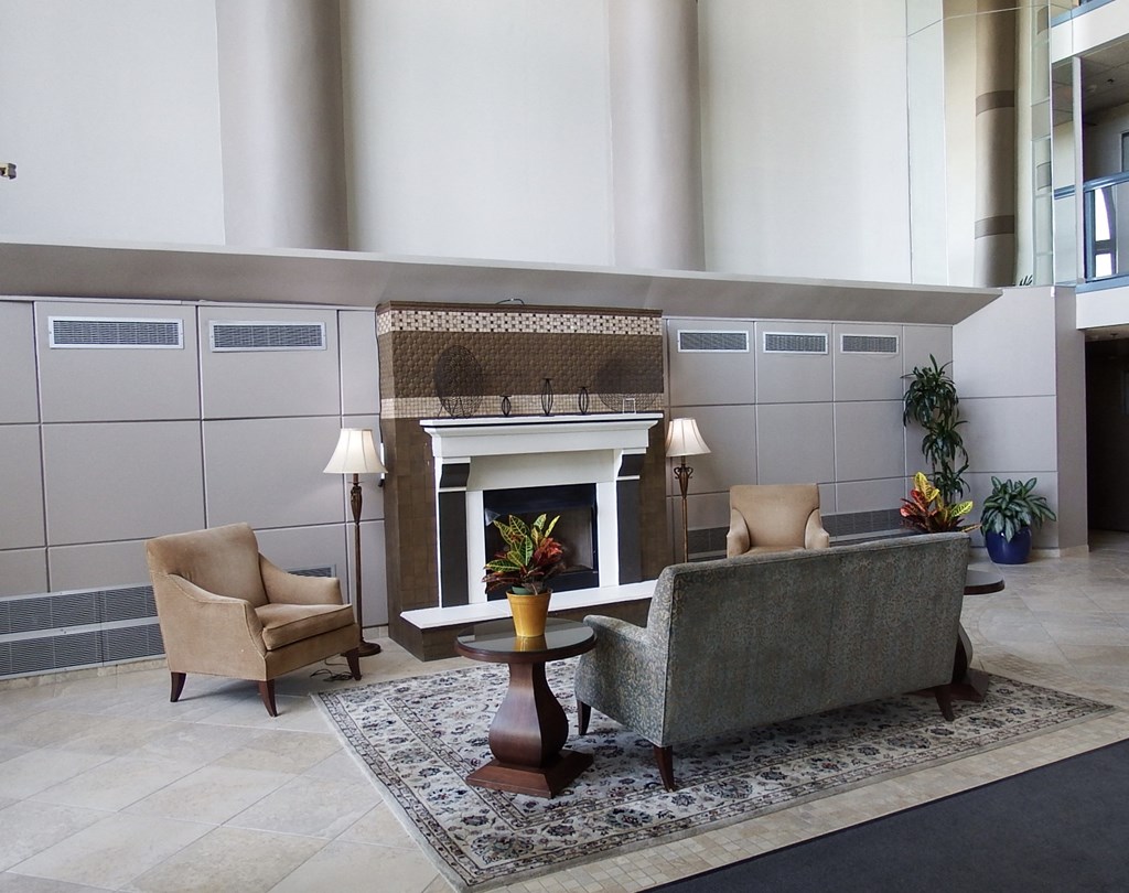 a living room with a fireplace and chairs