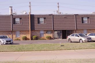 the front of a brick building with cars parked in front