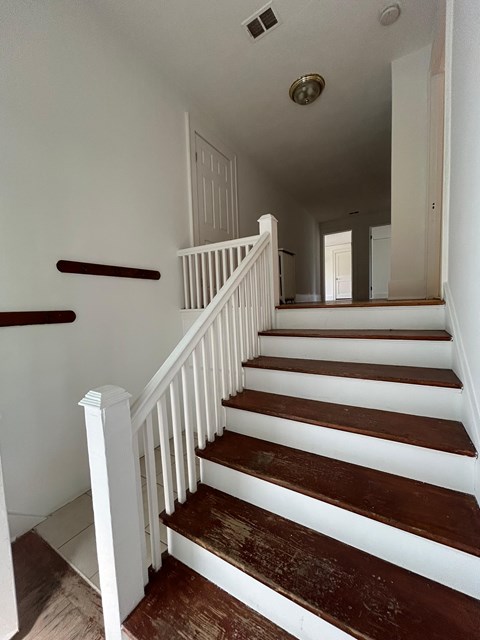 A staircase with white railings and wooden steps.