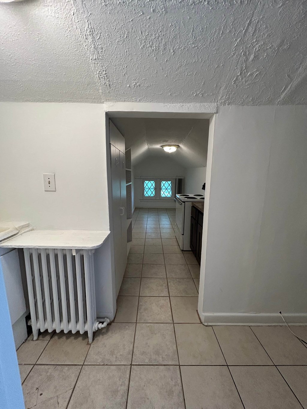 A white room with a window and a radiator.