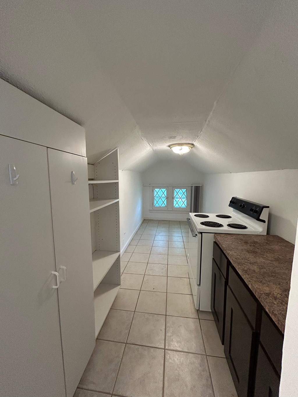 A kitchen with white cabinets and a stove top oven.