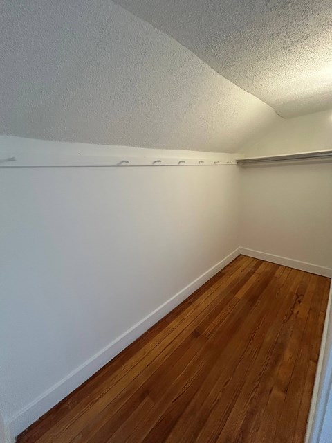 A room with wooden flooring and white walls.