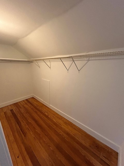 A room with a white wall and a wooden floor.