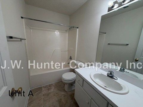 A bathroom with a toilet, sink, and shower.