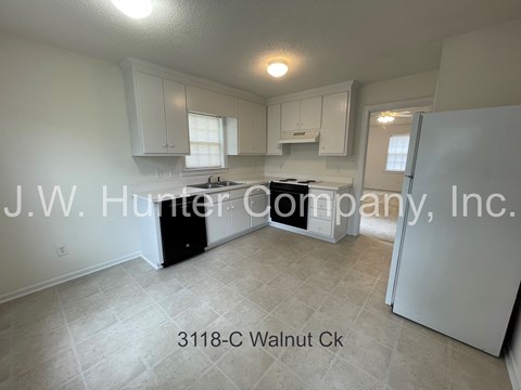A kitchen with white cabinets and a black stove top oven.