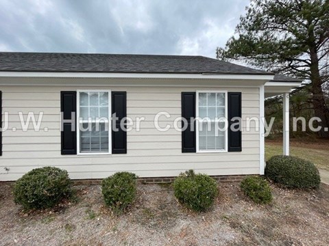 A house with a sign that reads "J.W. Hunter Company Inc." in front of it.