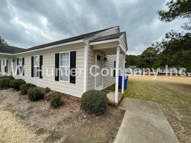A mobile home with a white porch and black shutters.