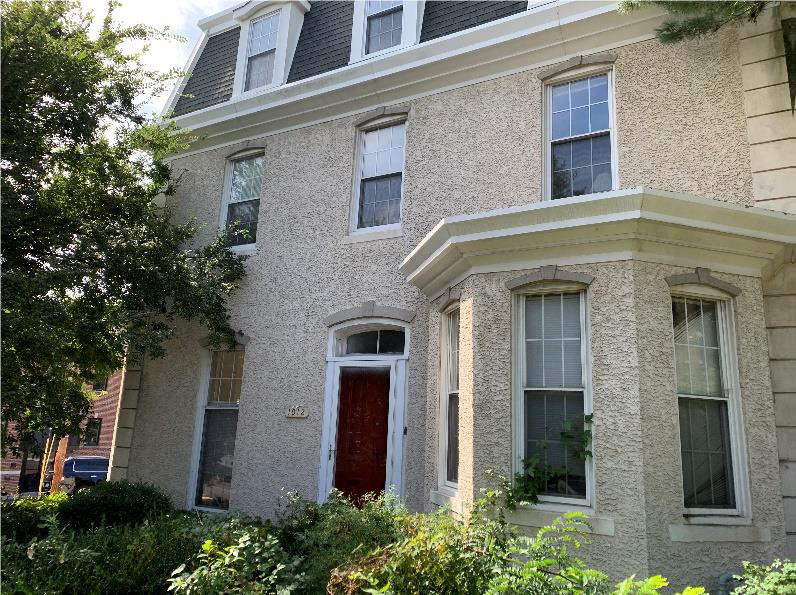 a brick house with a red door and windows