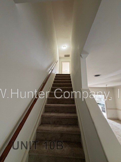 A staircase in a building with the text "V.Hunter Company" and "UNIT 10B" on the wall.