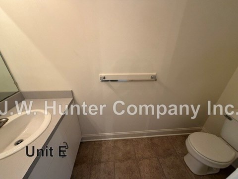 A bathroom with a toilet, tub, and radiator.