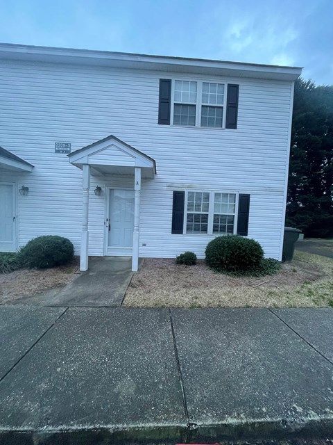 A white house with a black door and windows.