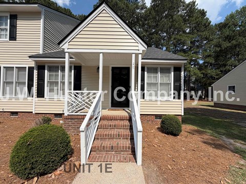 A house with a front porch and a sign that says "Unit 1E".