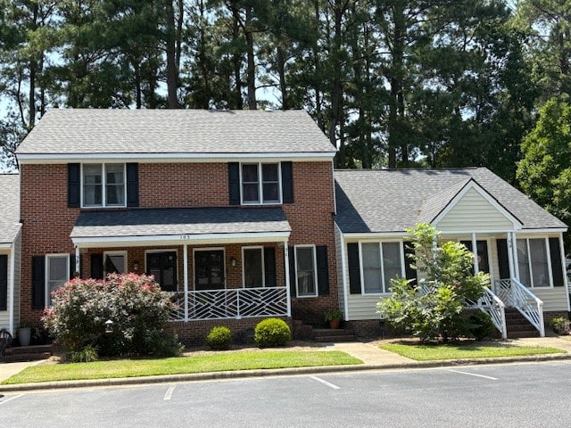 A two-story house with a brick facade and a white porch.
