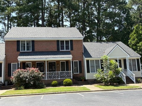 A two-story house with a brick facade and a white porch.