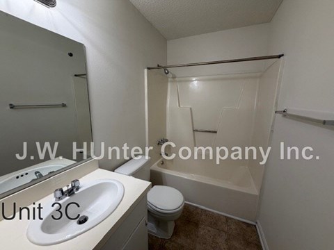 A bathroom with a sink, toilet and bathtub.