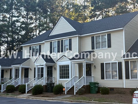 A two-story house with a white front porch and black shutters.