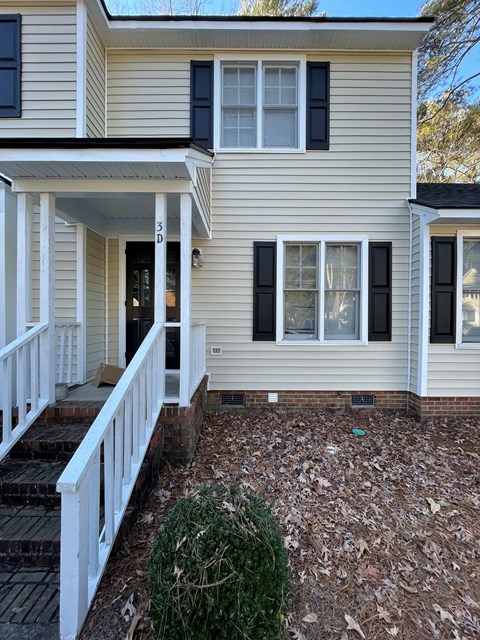 A house with a white porch and black shutters.
