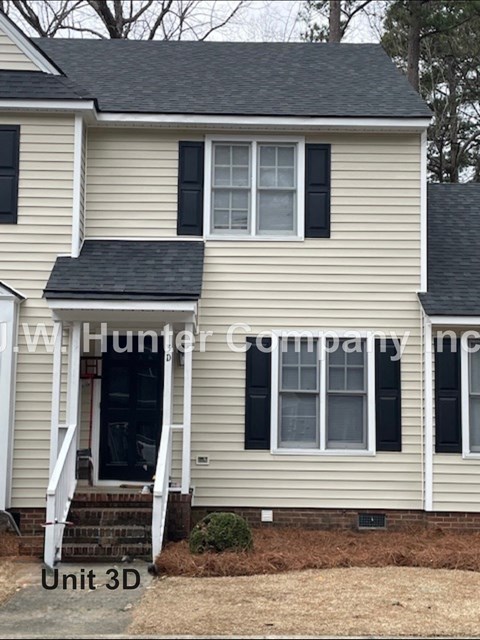 A house with a white door and black shutters is for sale.