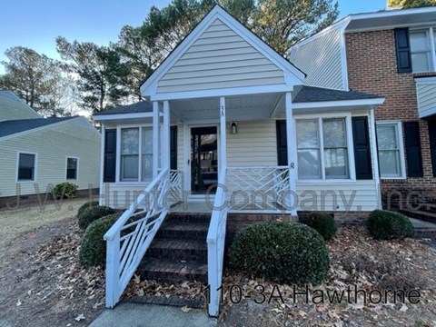 A small house with a front porch and stairs leading up to it.
