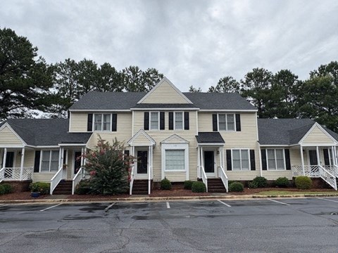A large house with a grey roof and white walls.