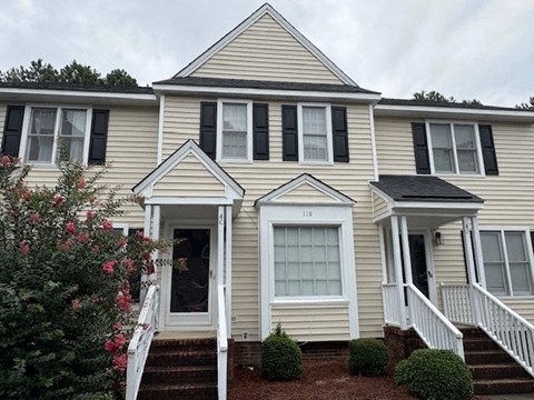 A house with a front yard and a white door.