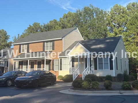 Two cars parked in front of a house with the text "W Hunter company Inc" on the side.