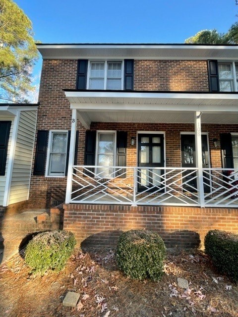 A house with a white porch and black shutters.