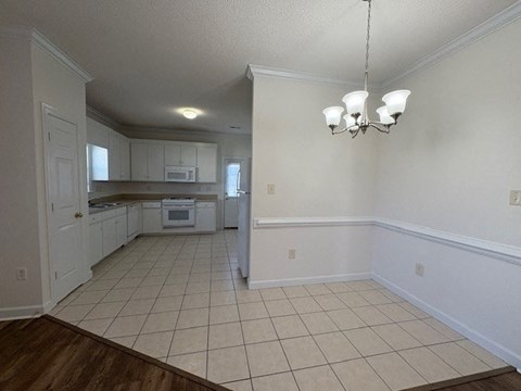 A kitchen with white cabinets and a white oven.