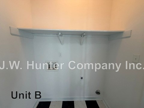 A white wall with a shelf and J.W. Hunter Company Inc. written on it.