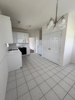 A kitchen with white cabinets and a white door.