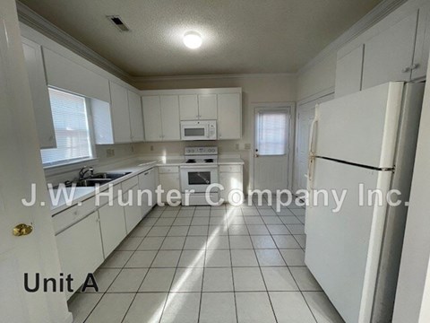A kitchen with white cabinets and appliances is labeled as Unit A.