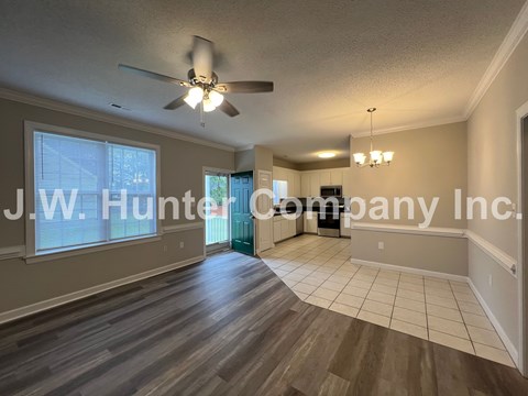 A spacious room with a ceiling fan and wooden flooring.