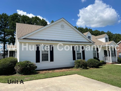 A white house with black shutters and a watermark that reads "Hunter Company".