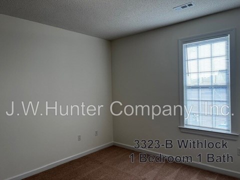 A room with a window and carpeting, with the text J.W. Hunter Company, Inc. and 3323-B Withlock 1 Bedroom 1 Bath.