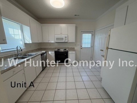 A kitchen with white cabinets and a black dishwasher.