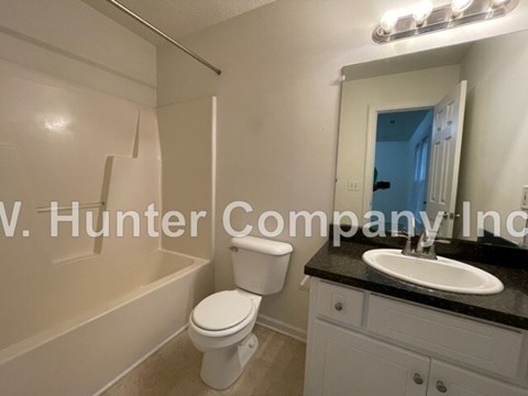 A white toilet and sink in a bathroom.