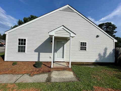 A small white building with a door and windows.