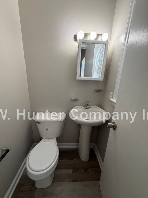 A white toilet in a small bathroom with a mirror above it.