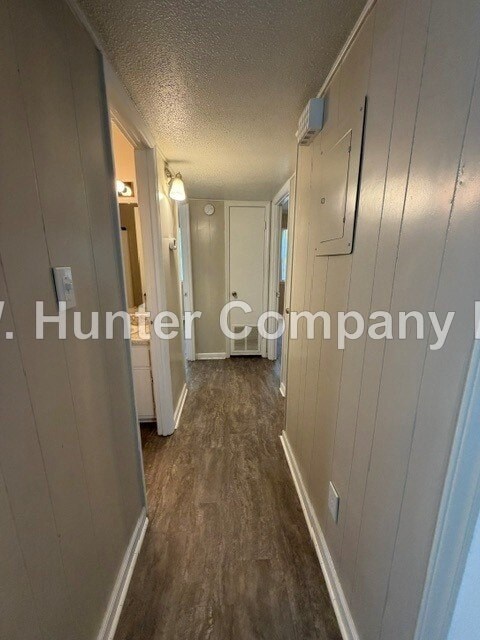 A long, narrow hallway with a white door at the end.