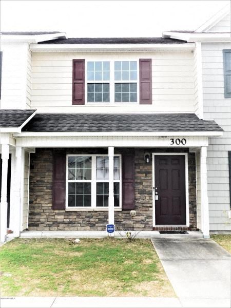a white house with a black door and a sidewalk
