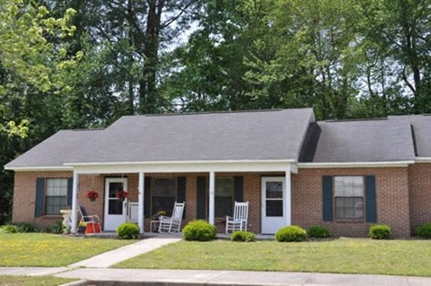 a brick house with two rocking chairs in front of it