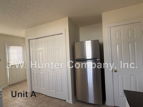 A kitchen with a stainless steel refrigerator and white doors.