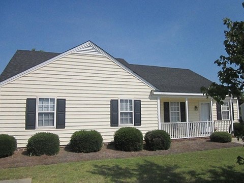 a white house with black shutters and a lawn