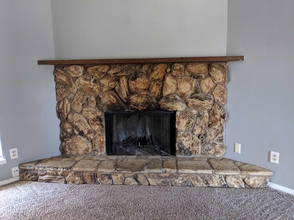 stone fireplace in the living room of a house